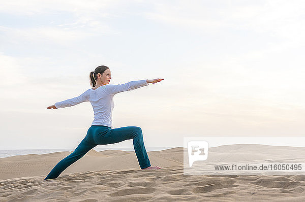 Frau übt Yoga bei Sonnenuntergang in den Dünen  Gran Canaria  Spanien