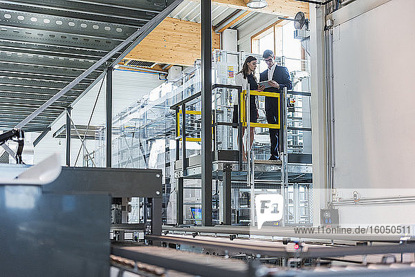 Manager planen über ein digitales Tablet  während sie in der Fabrik stehen