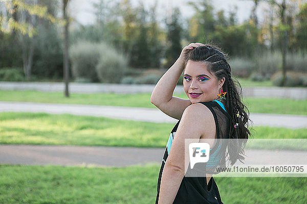 Teenager girl with down syndrome wearing 80's colorful make-up and clothes