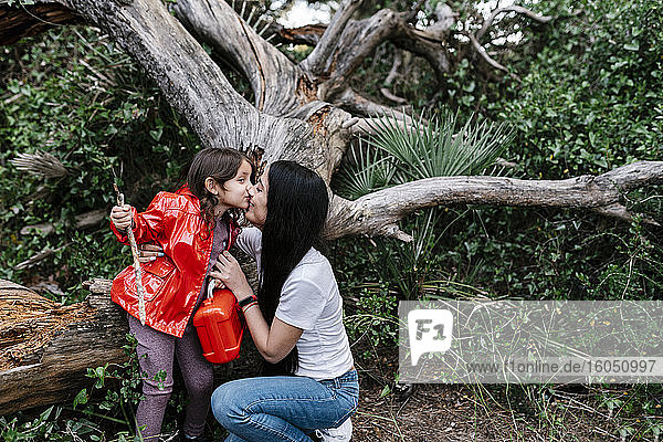 Mutter küsst ihre Tochter im Wald