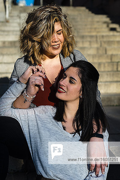 Close-up of lesbian couple sitting on steps in city