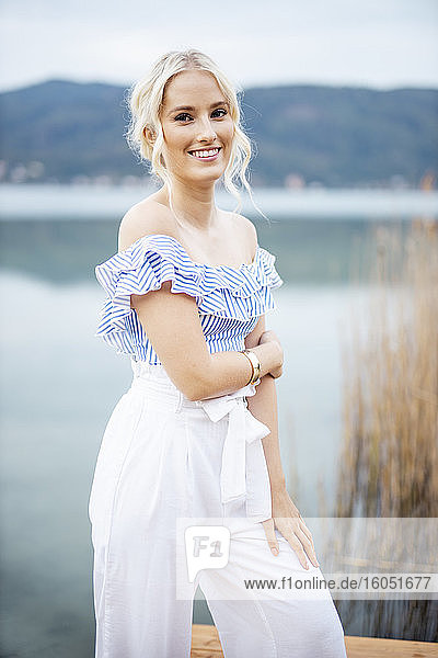 Porträt einer modischen blonden Frau auf einem Steg am Wörthersee  Österreich