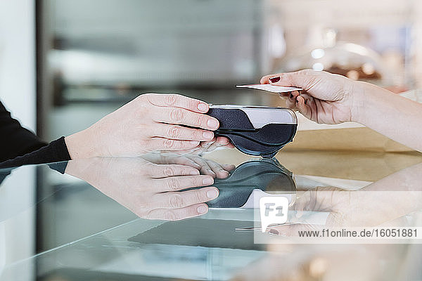 Kunde zahlt mit Kreditkarte in einer Bäckerei