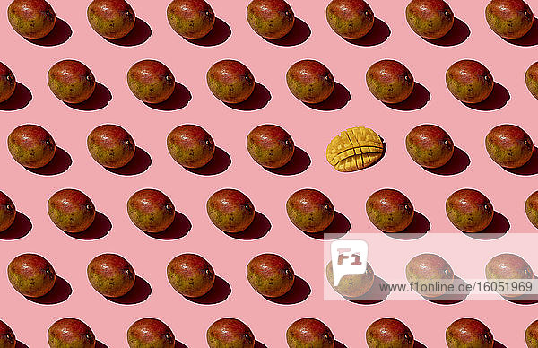 Ganze und eine zerkleinerte Mango Muster auf rosa Hintergrund