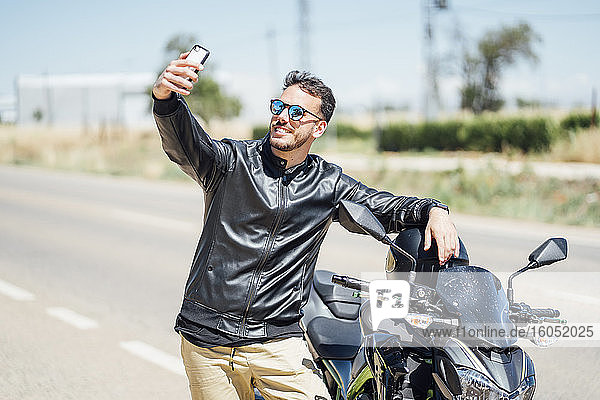 Biker mit Motorrad machen ein Selfie