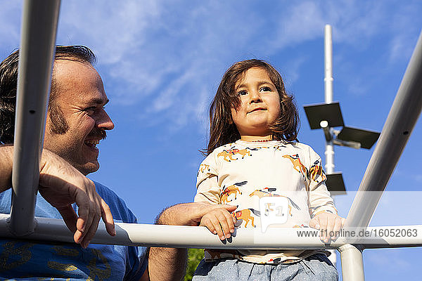 Porträt eines kleinen Mädchens und ihres Vaters auf dem Spielplatz