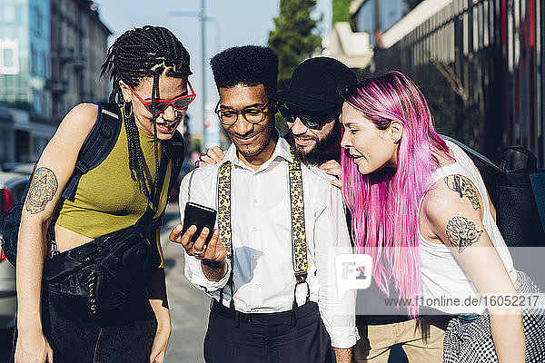 Eine Gruppe von Freunden teilt sich ein Smartphone in der Stadt