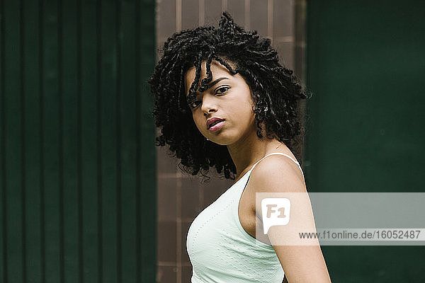 Young beautiful woman with black curly hair standing outdoor