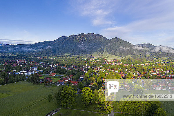 Deutschland  Bayern  Lenggries  Drohnenansicht einer Stadt auf dem Land mit dem Brauneck im Hintergrund