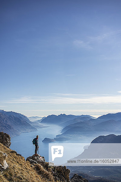 Hiker standing on mountain  looking at Lake Como  Italy