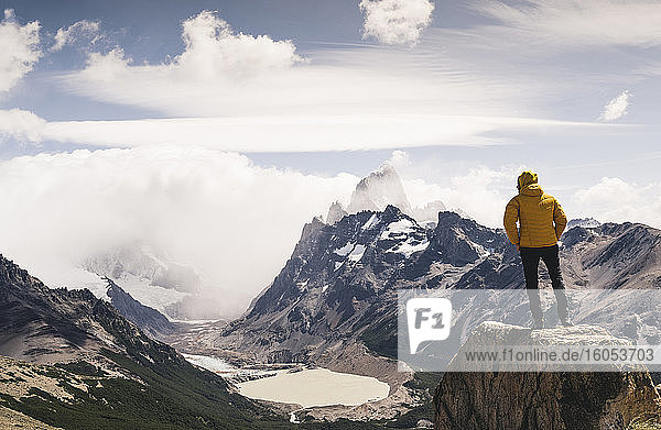 Man looking at snowcapped mountain against cloudy sky  Patagonia  Argentina