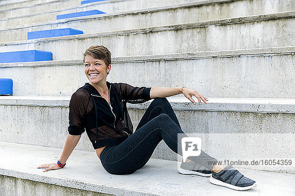 Sportliche Frau auf der Treppe sitzend