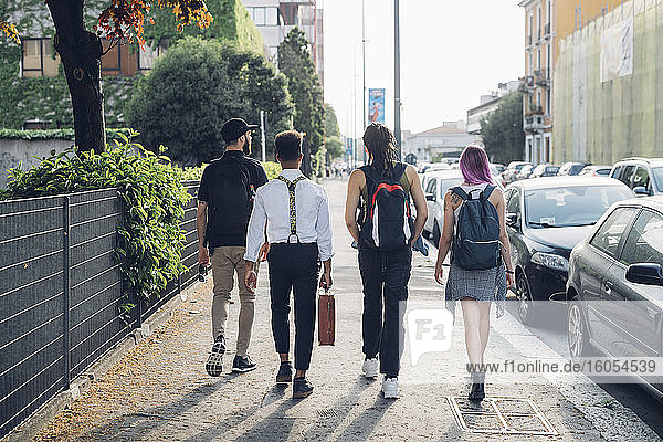 Group of friends walking on pavement in the city