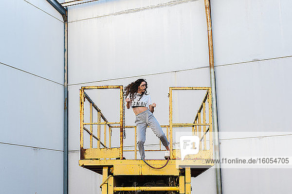 Weibliche Hip-Hop-Tänzerin tanzt auf einer Metallplattform in einem verlassenen Gebäude