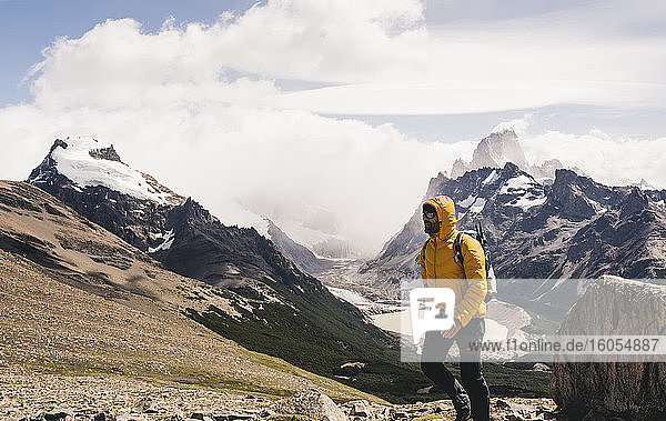 Mann geht auf Berg gegen bewölkten Himmel  Patagonien  Argentinien