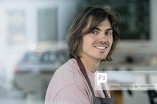 Close-up of smiling male owner working in coffee shop