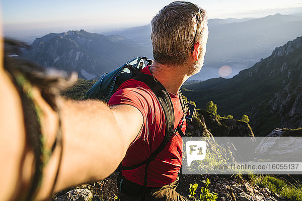 Älterer Mann betrachtet die Aussicht  während er bei Sonnenuntergang auf einem Berg steht  Orobie  Lecco  Italien