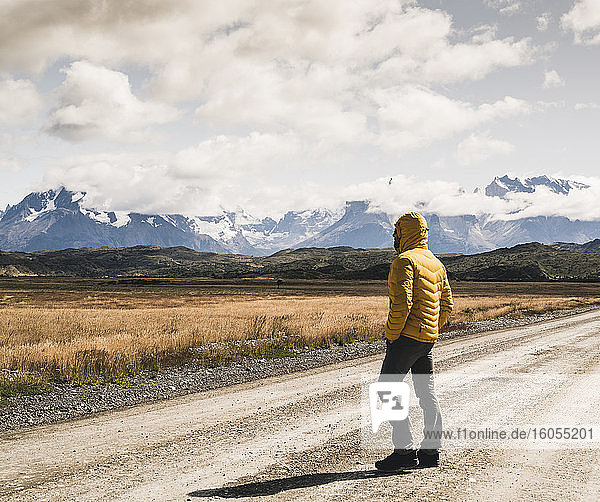 Man standing on dirt road against cloudy sky at Torres Del Paine National Park  Patagonia  Chile