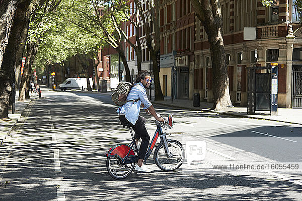 Young man using rental bike in the city  London  UK
