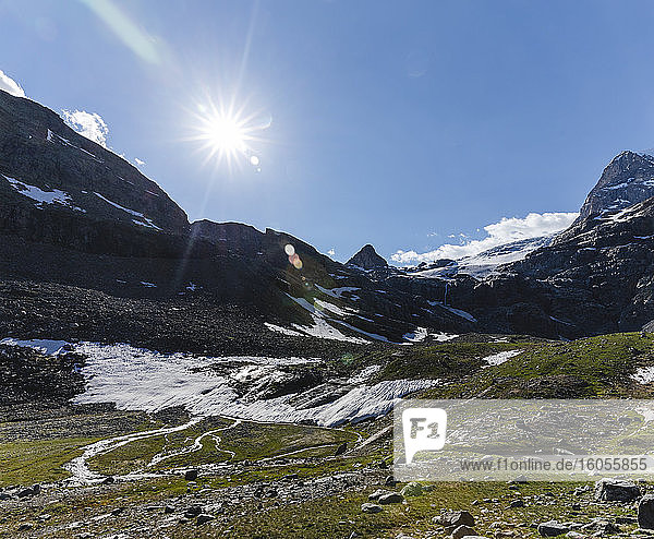 Landschaftliche Ansicht einer Bergkette mit schmelzenden Gletscherströmen gegen den Himmel an einem sonnigen Tag