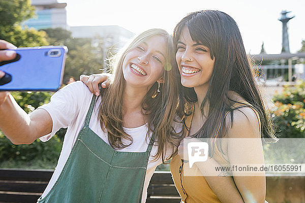 Porträt von zwei glücklichen Freunden  die ein Selfie mit einem Smartphone machen