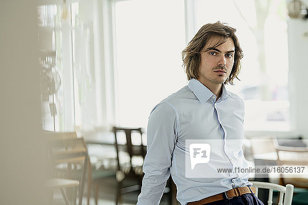 Selbstbewusster Geschäftsmann in einem Café sitzend