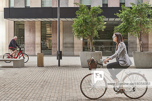 Businesswoman commuting on bicycle in city