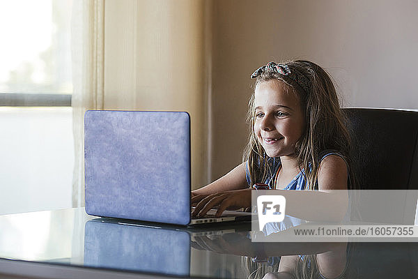 Mädchen benutzt Laptop zu Hause