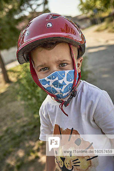 Nahaufnahme eines Jungen mit Maske und rotem Helm  der im Freien steht