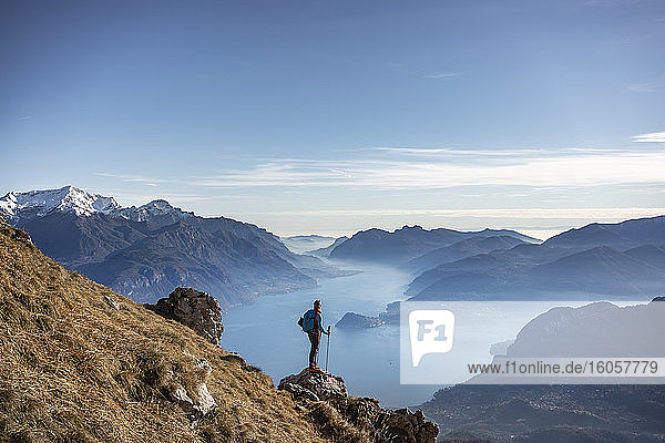 Hiker standing on mountain  looking at Lake Como  Italy