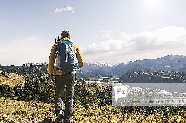 Male hiker with backpack walking on landscape against sky  Patagonia  Argentina