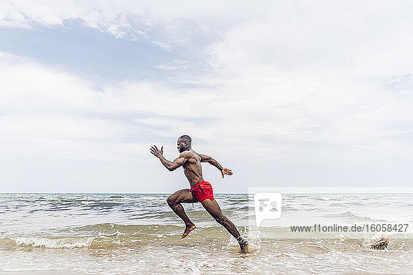 Sportlicher Mann läuft am Strand