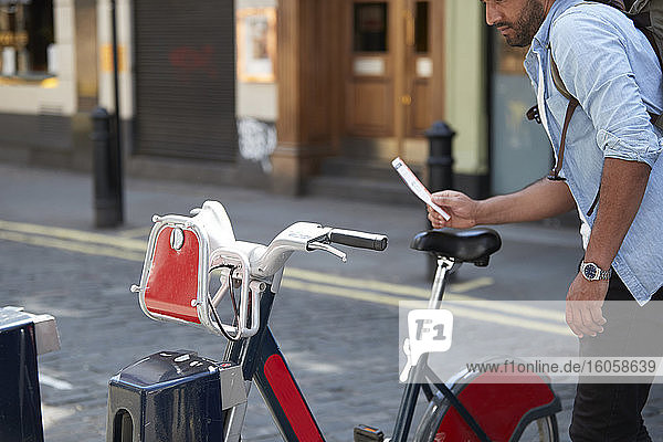 Crop view of man using rental bike in the city  London  UK
