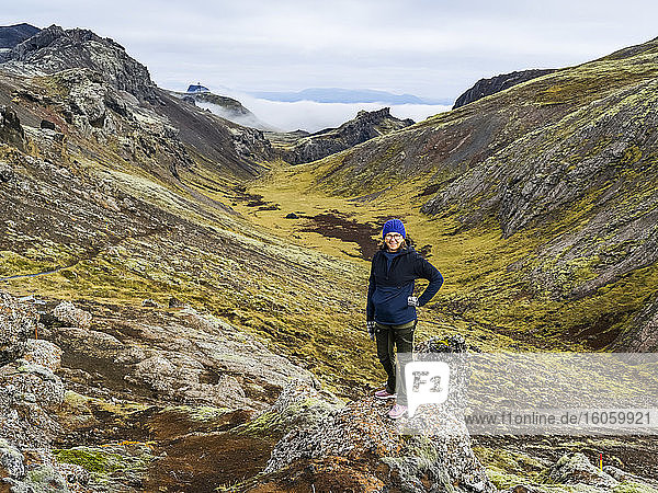 Eine Frau steht auf dem zerklüfteten Gelände im Süden Islands; Grimsnes- og Grafningshreppur  Südliche Region  Island