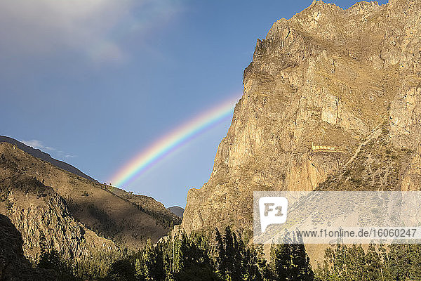Regenbogen zwischen zwei Bergen. Auf dem Berg rechts befinden sich Inka-Ruinen; Ollantaytambo  Cusco  Peru