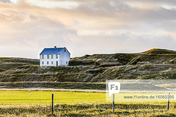 Weißes Haus auf Grashügel in Südisland; Myrdalshreppur  Region Süd  Island