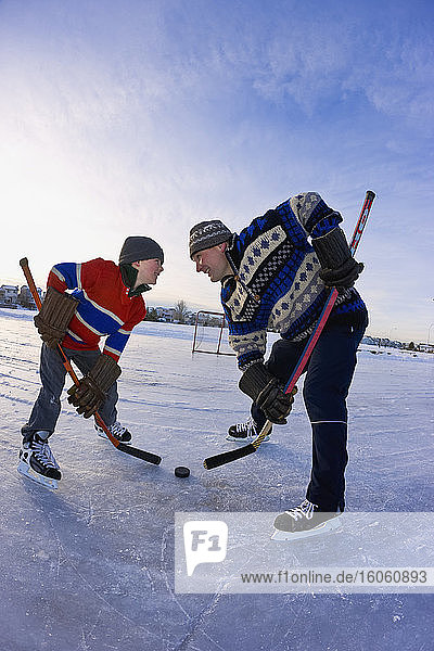 A father and son in a hockey faceoff; Alberta  Canada