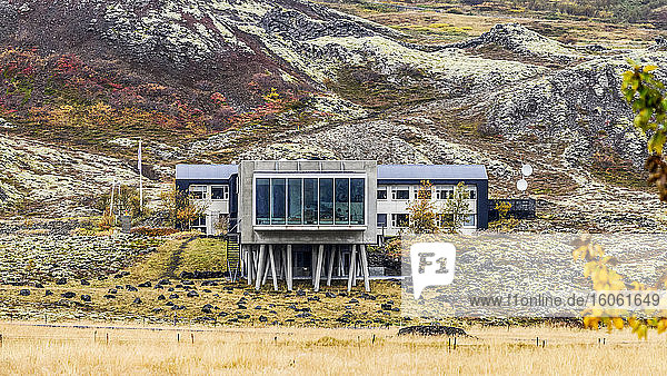 Gebäude mit großen Fenstern auf karge Landschaft mit Herbstfarben; Island