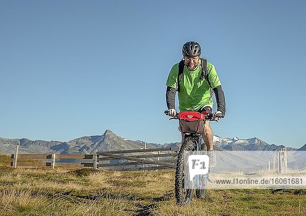 Mountain biker in his late forties rides on an ebike along an alpine path against a blue sky  Bergeralm leisure arena  bike park  Gries am Brenner  Tyrol  Austria  Europe