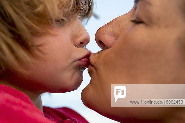close up of mother kissing her 5 year old songg