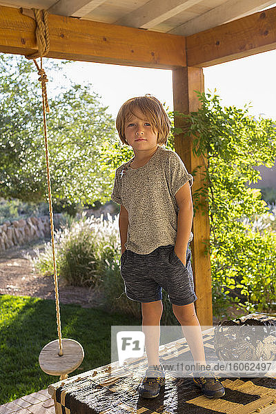 Porträt eines 4 Jahre alten Jungen auf seiner Veranda