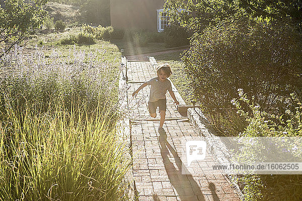 4 Jahre alter Junge rennt auf Ziegelsteinpfad
