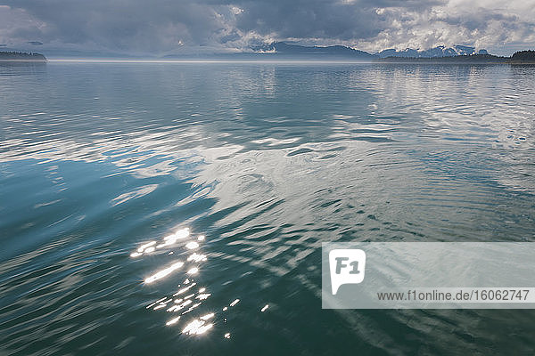 Sonnenlicht reflektiert das ruhige Wasser des Muir-Einzugs im Glacier Bay National Park Alaska in der Abenddämmerung