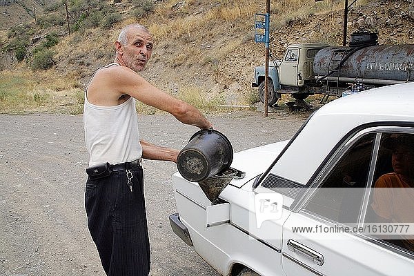 A petrol station in Armenia. The owner fills the car by hand from a bucket. Photo: Andr? Maslennikov