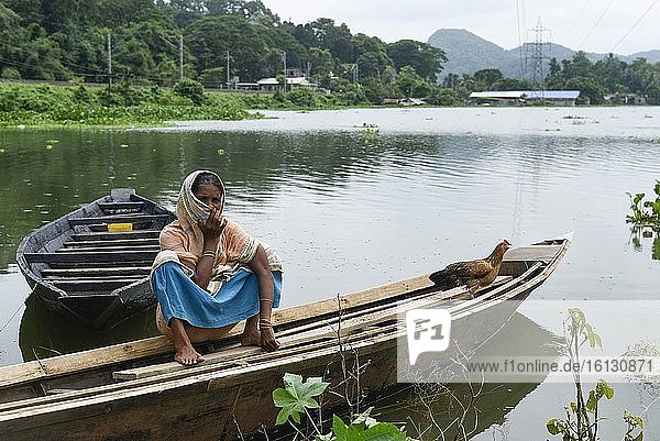 Eine Frau sitzt auf einem Boot in einem vom Hochwasser betroffenen Dorf im Bezirk Kamrup in Assam  Montag  13. Juli 2020.