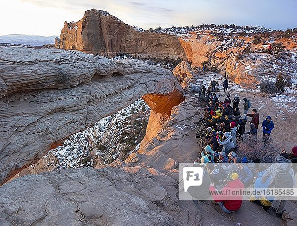 Arch Mesa Arch at sunrise  many photographers and tourists  Colorado River Canyon  at Grand View Point Trail  Island in the Sky  Canyonlands National Park  Utah  USA  North America