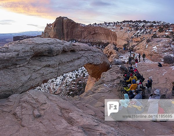 Arch Mesa Arch at sunrise  many photographers and tourists  Colorado River Canyon  at Grand View Point Trail  Island in the Sky  Canyonlands National Park  Utah  USA  North America