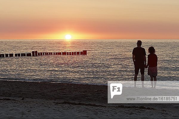 Pärchen händchenhaltend  beobachtet Sonnenuntergang an der Ostsee  Kühlungsborn  Mecklenburg-Vorpommern  Deutschland  Europa