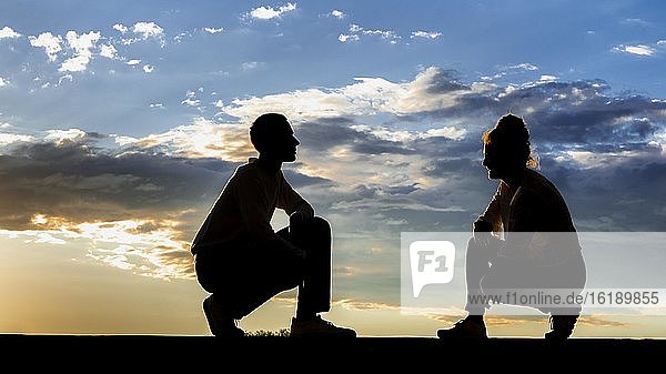 Mann  21 Jahre  Frau  23 Jahre  Silhoütte  sitzend  im Sonnenuntergang  Remstal  Baden Württemberg  Deutschland  Europa