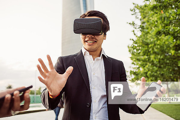 Portrait of Asian businessman wearing VR headset.